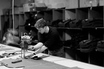 Person working with a cutting machine and equipment in a workshop setting