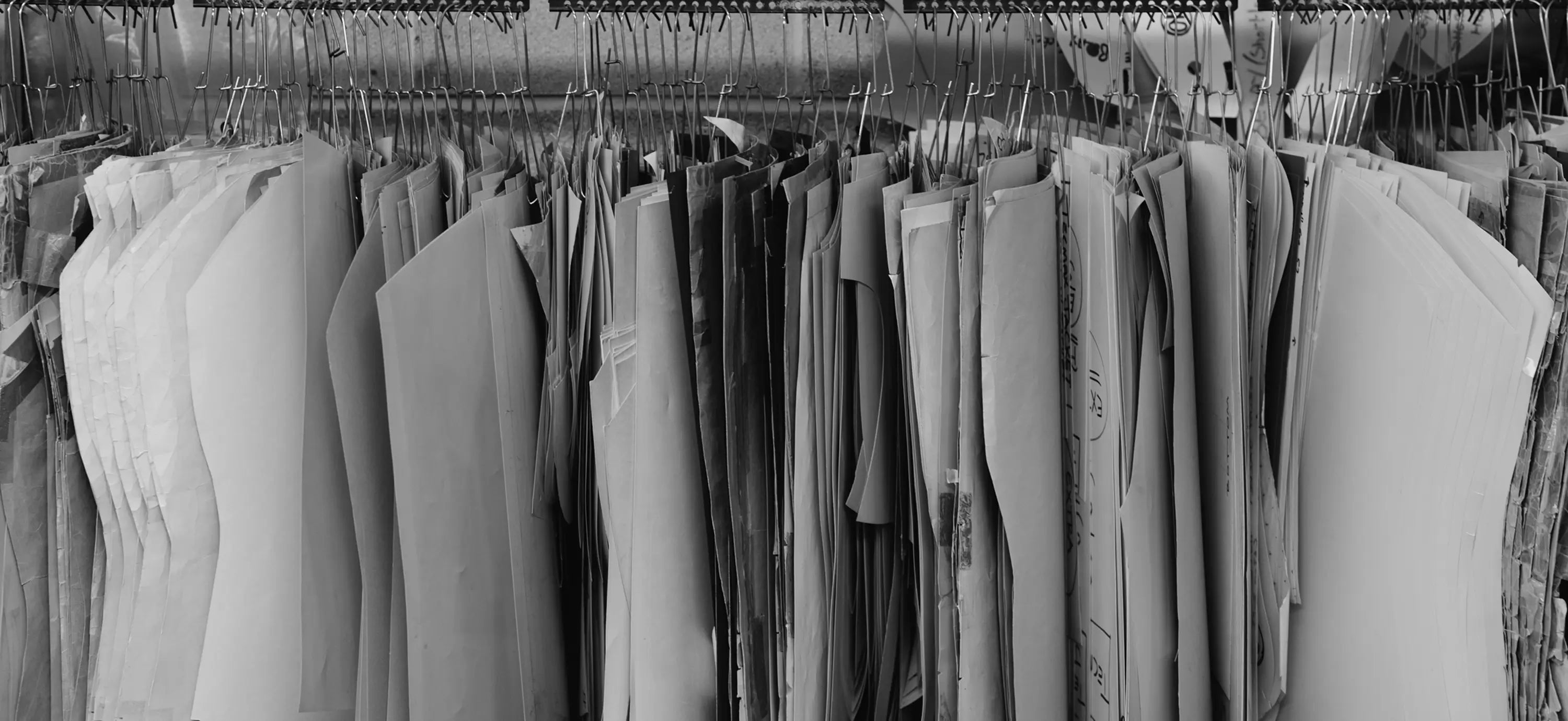 Collection of gray fabric swatches on hangers in a room 