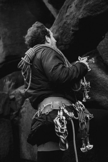 Person climbing a rock wall with climbing gear wearing Buffalo Systems jacket