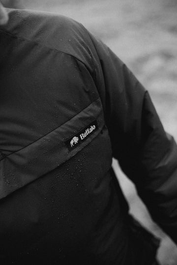 Black jacket with a visible buffalo systems logo on a blurred background