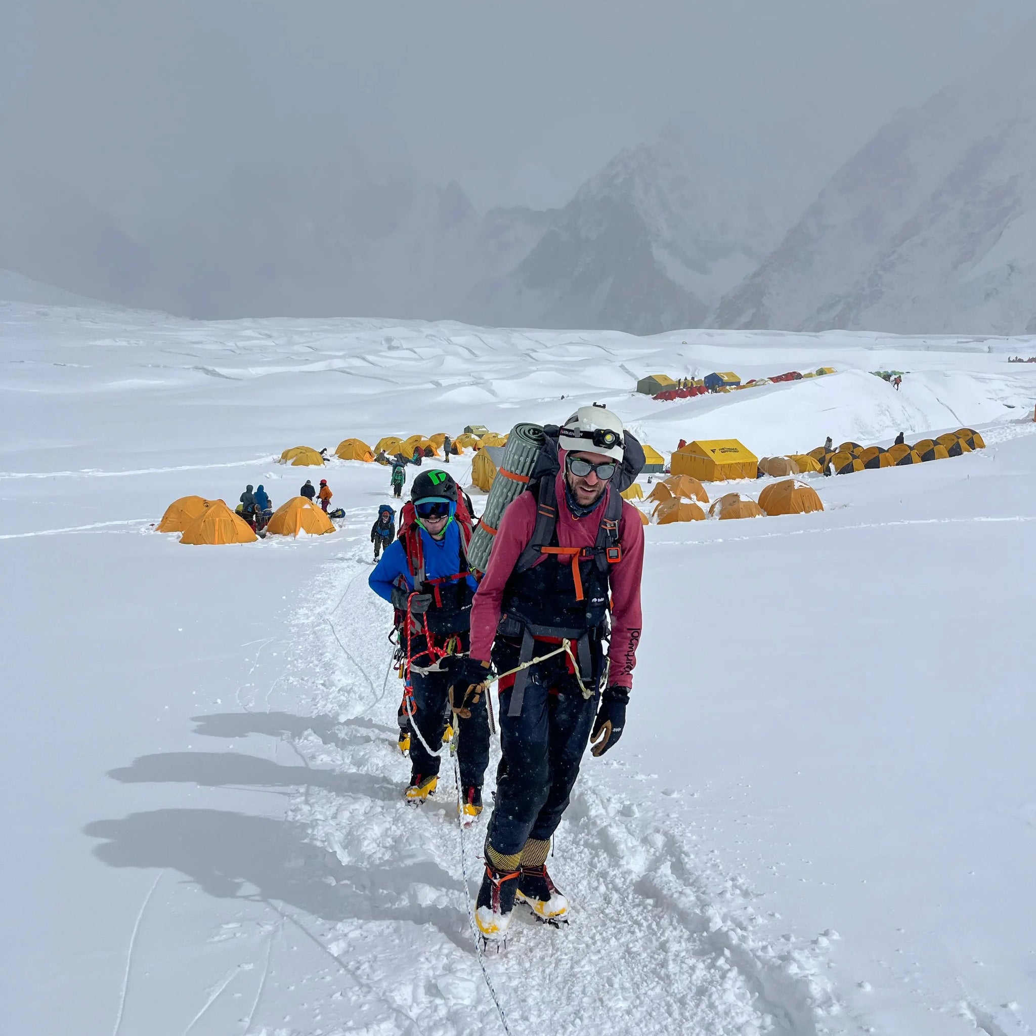 Two climbers on a snowy mountain on a mountain rescue mission wearing buffalo systems gear
