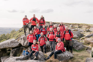 Mountain Rescue team in red jackets posing on a rocky landscape