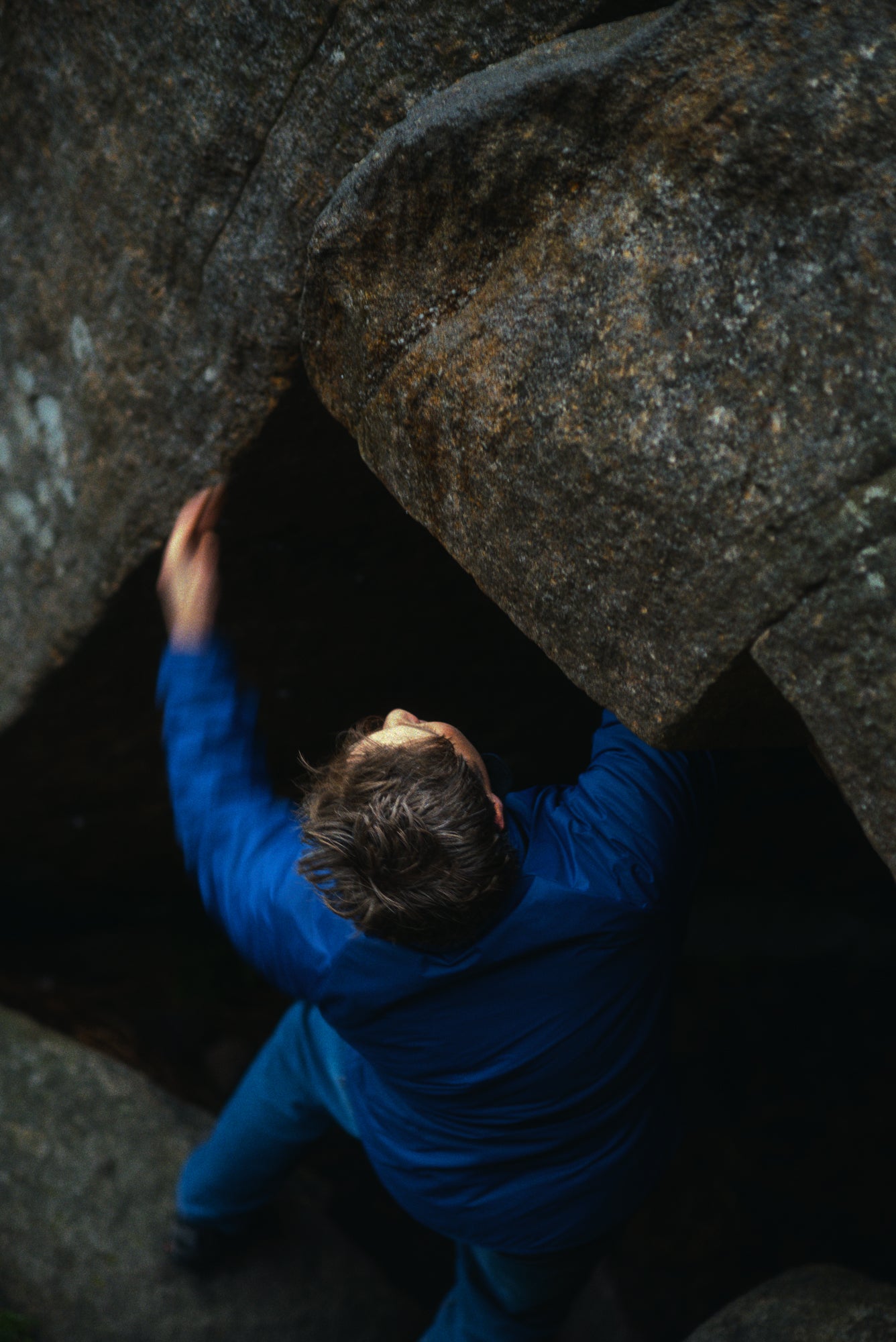 Person in a blue jacket climbing a rocky wall